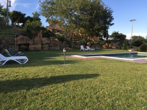 a yard with chairs and a swimming pool at Villa Fonte all'Oppio con area piscina recintata in Pienza