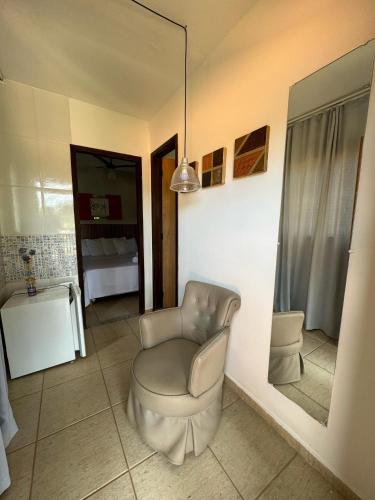 a living room with a chair and a mirror at Veredas do Cipó in Serra do Cipo
