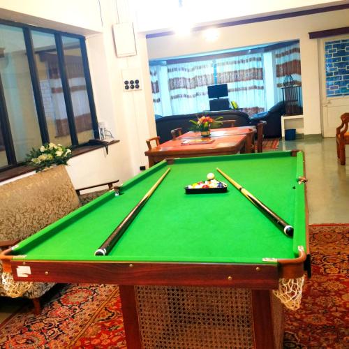 a pool table with two cuesticks on top of it at Waterfield Bungalow by Liyozi Leasiure in Nuwara Eliya