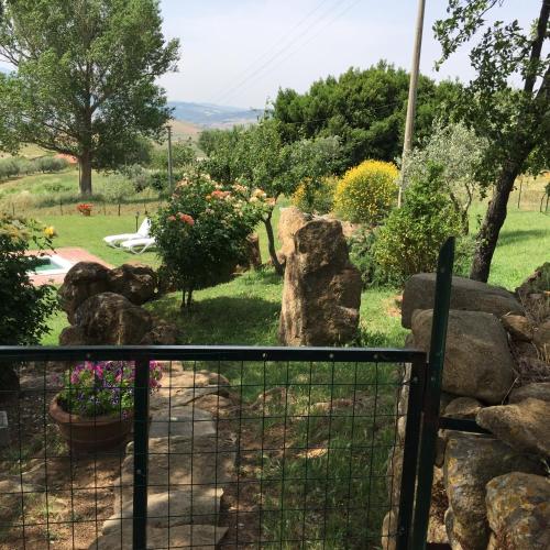 a garden with a fence and some flowers at Villa Fonte all'Oppio con area piscina recintata in Pienza
