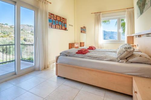 Un dormitorio con una cama y una ventana grande. en Villa Vista Almuñécar, en Granada