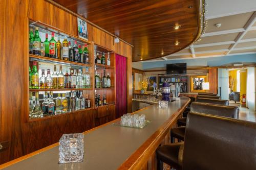 a bar in a restaurant with a lot of alcohol at Hotel Athmos in La Chaux-de-Fonds