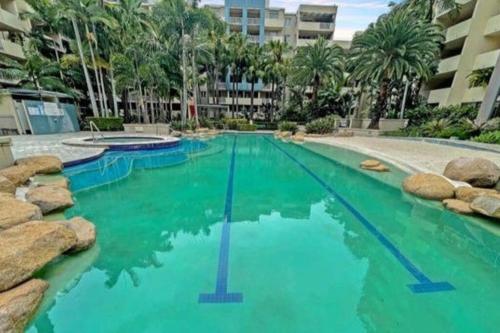 a swimming pool with turquoise water in a resort at Large studio balcony, spa & pool in Brisbane