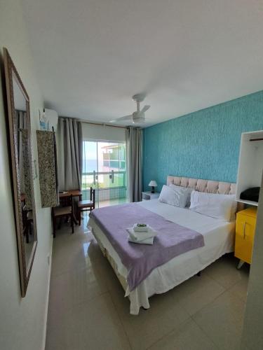 a bedroom with a large bed with a blue wall at Hotel Aconchego Da Vila in Saquarema