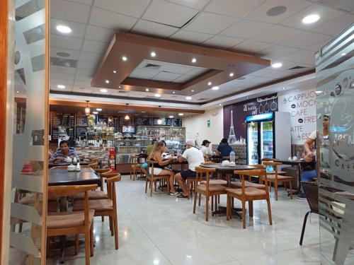 un restaurante con gente sentada en mesas. en Arena Hostal, en Paracas