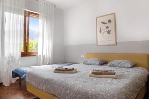 a bedroom with a bed with two towels on it at Terrassen Wohnung Bacio del Sole in Maccagno Inferiore
