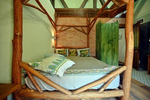un letto in una camera con telaio in legno di Pensiunea Tihna a Râu de Mori