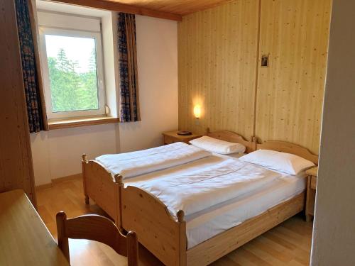 a bedroom with a bed and a window at Apparthotel Germania in Dobbiaco