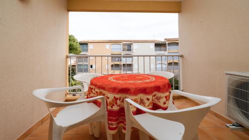 une table et des chaises sur un balcon avec vue dans l'établissement Le Jean Barth II - 35 - Appt lumineux 6 pers, au Cap d'Agde