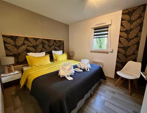 1 dormitorio con 1 cama con toallas en Lodge spa privatif Sylvestre, séjour zen, en Meisenthal