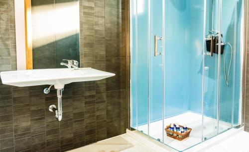 een badkamer met een wastafel en een douche bij Casa Rural Viña Vella in Esteiro