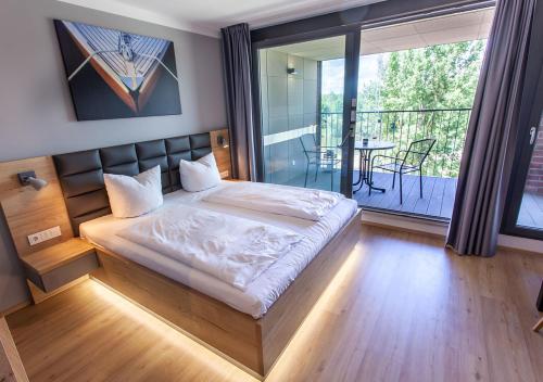 a bedroom with a large bed and a balcony at Marina Apartments Regensburg in Regensburg