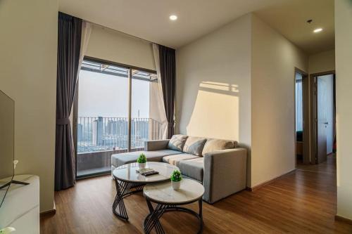 Condo 2 Bedrooms Luxury Condo Checkin 24h Infinity Pool 360 في بانكوك: غرفة معيشة مع أريكة وطاولة