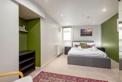 ein Schlafzimmer mit grünen und weißen Wänden und einem Bett in der Unterkunft Gibson Place - 15 Secs to The Old Course: Parking Nearby in St Andrews