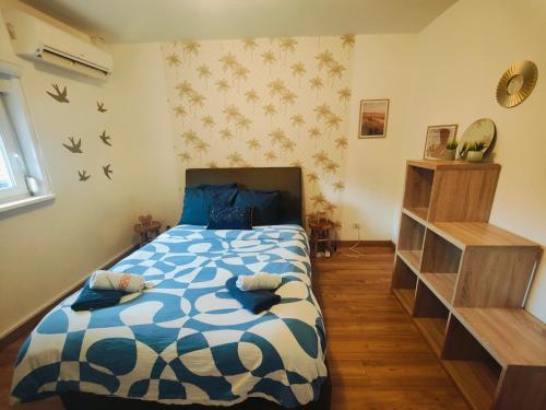 um quarto com uma cama com um edredão azul e branco em Chambre climatisée cosy Auberge du Manala Hôtel 24-24 em Saint-Louis