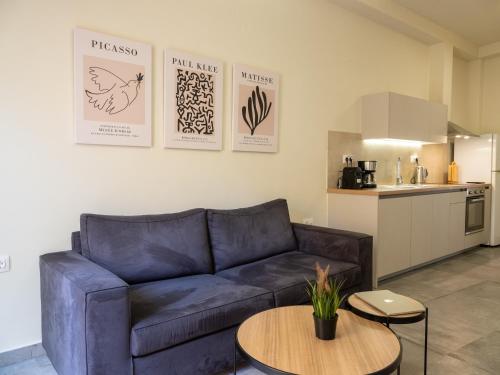 ein Wohnzimmer mit einem blauen Sofa und einem Tisch in der Unterkunft Casa Del Centro Storico,By IdealStay Experience in Iraklio