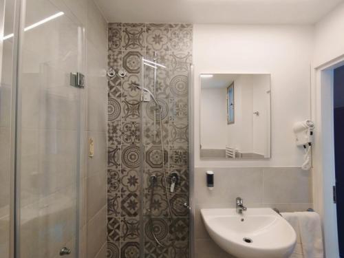 uma casa de banho com um chuveiro e um lavatório. em Hotel Excelsior em Cervia