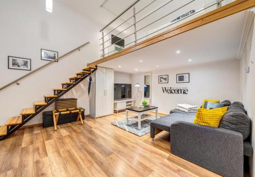 a living room with a couch and a staircase at Sweet Dreams at Oktogon in Budapest