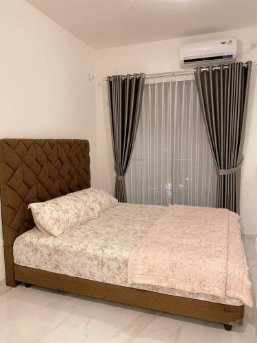 a bedroom with a bed and a window with curtains at NAY Room at sky house BSD in Samporo