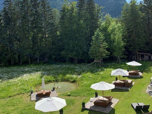 a group of tables with umbrellas in a field at Apparthotel Germania in Dobbiaco