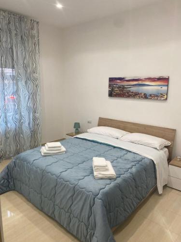 ein Schlafzimmer mit einem Bett mit zwei Handtüchern darauf in der Unterkunft MAKI HOME in Portici