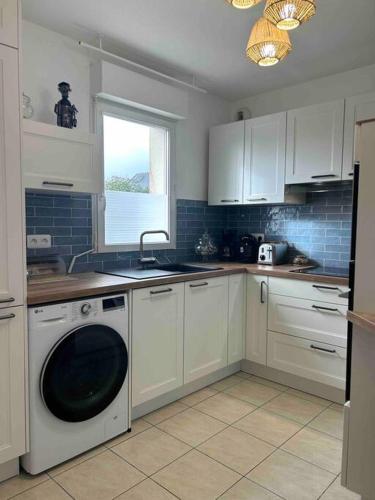 Il comprend une cuisine équipée d'un lave-linge, d'un évier et d'un lave-vaisselle. dans l'établissement Appartement Etape en presqu'île, à Crozon