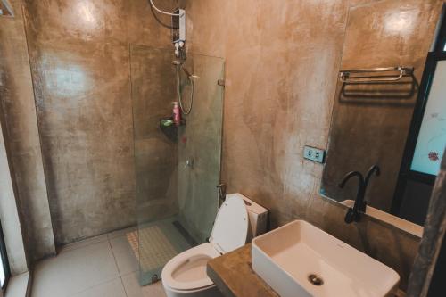 a bathroom with a shower and a toilet and a sink at Shalmari's Hut in South Tambo