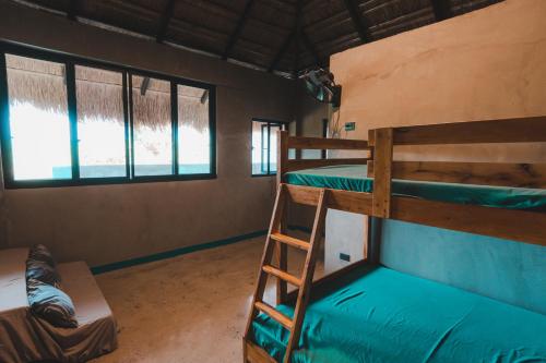 a room with two bunk beds and two windows at Shalmari's Hut in South Tambo