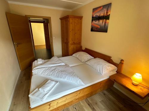 um quarto com uma cama grande e lençóis brancos em Auszeit im Thierseetal, Gemütliche Ferienwohnung in Tirol, FeWo 3 em Thiersee