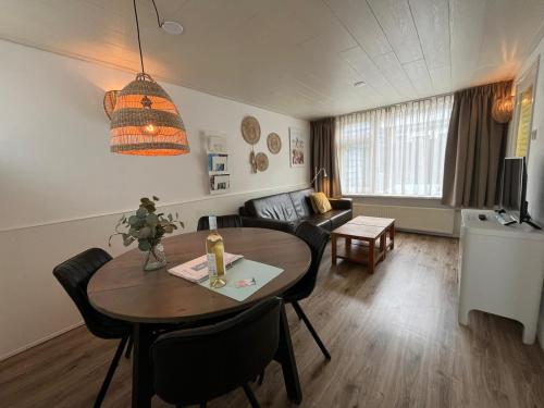 een woonkamer met een tafel en een bank bij Zomerhuis Beach EnJoy in Egmond aan Zee