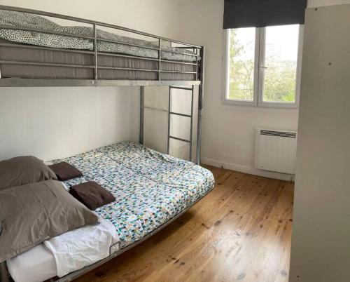 sypialnia z łóżkiem piętrowym i drewnianą podłogą w obiekcie Maison indépendante 7 minutes RER B w mieście Antony