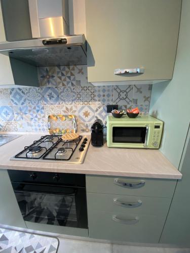 een keuken met een fornuis en een magnetron op een aanrecht bij I Limoni Casa Vacanza in Castelletto sopra Ticino