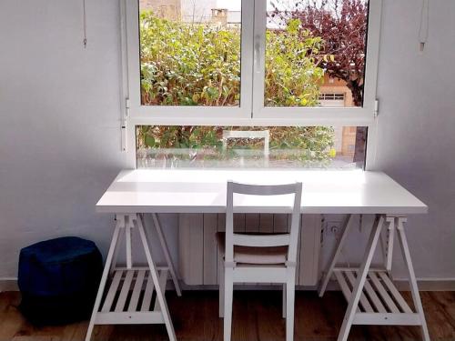 Apartamento Thematic OyM في بليانة: طاولة بيضاء و كرسيين أمام النافذة