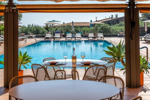 a patio with tables and chairs and a swimming pool at Hotel Sol Ixent - Adults Only in Cadaqués