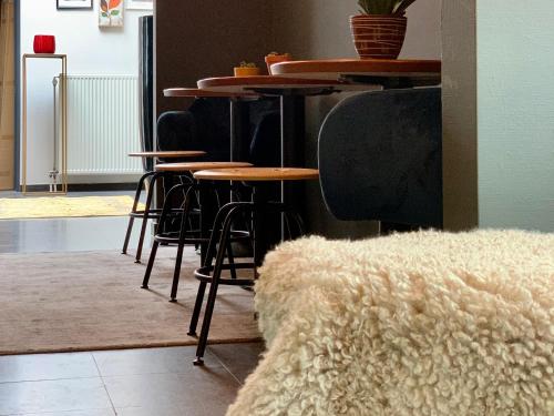 a group of tables and stools in a room at Guesthouse De Wissen in Dilsen-Stokkem