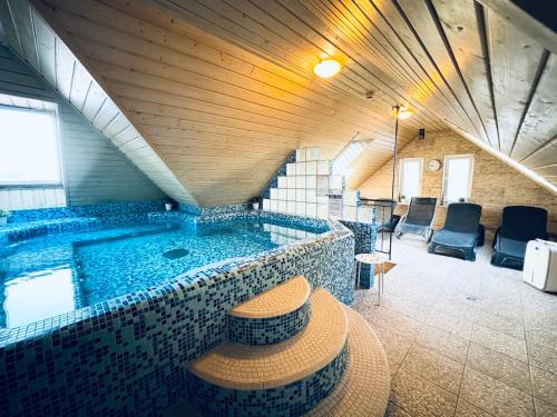 - une grande piscine dans un bâtiment avec une chambre dans l'établissement Libra Hotel, à Veresegyház