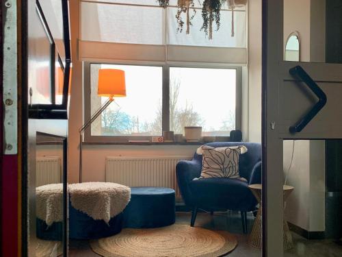 a living room with a chair and a window at Guesthouse De Wissen in Dilsen-Stokkem
