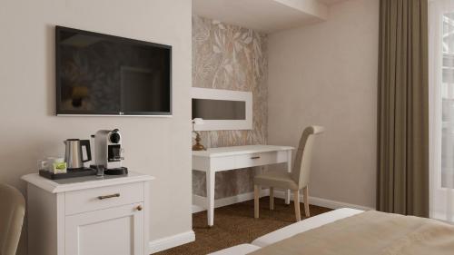 a hotel room with a desk and a tv at Hotel Savoy Prague in Prague