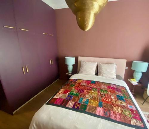 um quarto com uma cama com uma colcha colorida em Apartment close to the beach - 3 min walk em Nice