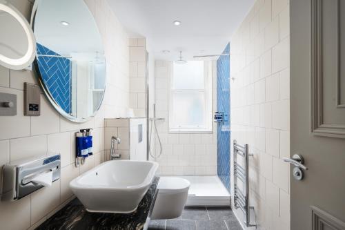 een badkamer met een wastafel, een toilet en een spiegel bij Hotel Indigo - Edinburgh - Princes Street, an IHG Hotel in Edinburgh
