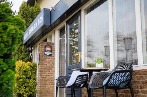 una mesa y dos sillas frente a una tienda en Hotel Berg en Bos en Apeldoorn