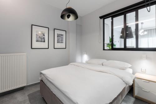 a white bedroom with a large bed and a window at #Nereids Apts by halu! Apartments in Thessaloniki