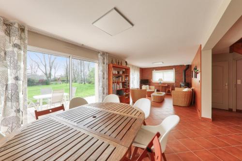 une salle à manger avec une table et des chaises en bois dans l'établissement Maison 4 chambres - Tour du Parc, à Le Tour-du-Parc