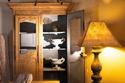 a lamp sitting next to a room with a cabinet at Une pause en Provence au Village des antiquaires de la Gare in LʼIsle-sur-la-Sorgue