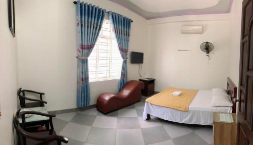 a bedroom with a bed and a chair and a window at Ninh Nguyệt Motel in Sơn Tây