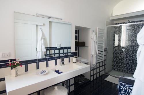 W łazience znajduje się biała umywalka i prysznic. w obiekcie Beatrice Luxury Apartment w mieście Vietri sul Mare
