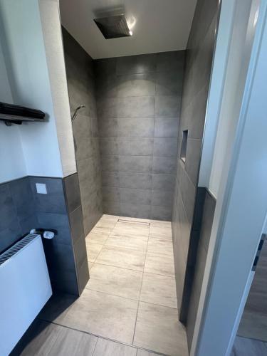 a bathroom with a shower with a tile floor at FeWo Murach 1 in Horrweiler