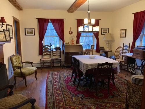 a living room with a table and a piano at Timber Post Bed & Breakfast in Nashua