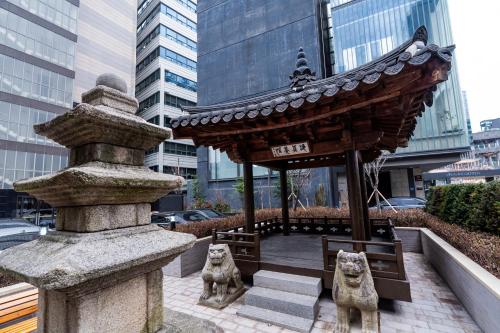 a pavilion with two statues of cats on a city street at The Prima Hotel Jongno in Seoul