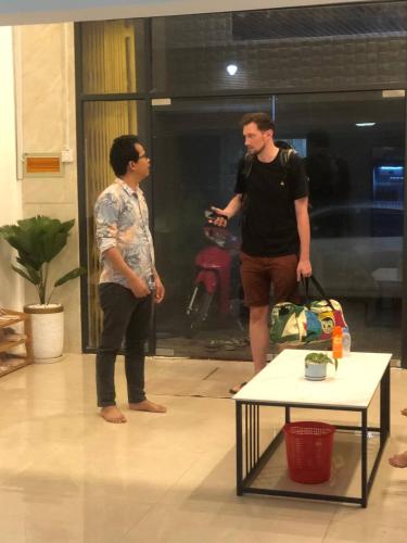 two men standing in a room with a table at White House Guesthouse in Phnom Penh